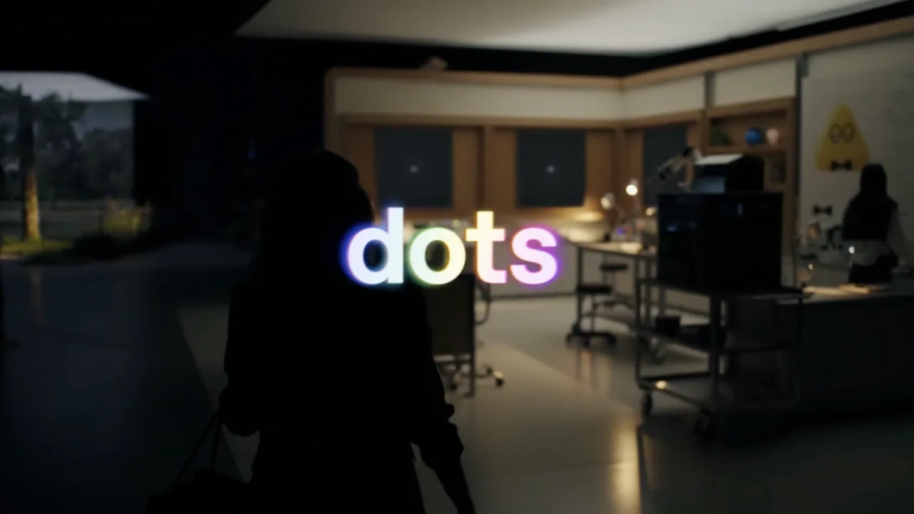 Ordet dots i regnbågsfärger ovanpå en mörk kontorsmiljö, från OpenAI:s lanseringsfilm för ChatGPT dots